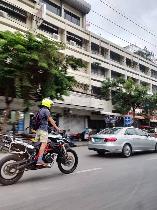 A rider on a loaded bike in Bangkok traffic